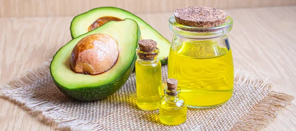 Ahşap arka planda avokado ve avokado yağı. Seçici odaklanma. Yemek