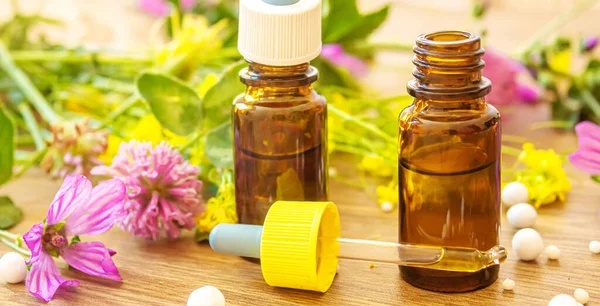 Şifalı bitkiler, küçük şişelerdeki yağlar homeopati. Seçici odaklanma. Doğa