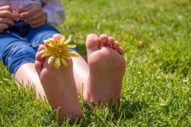 Çocuk yeşil çimlerin üzerinde yatıyor. Çocuk bahar parkında eğleniyor. Seçici odaklanma. insanlar