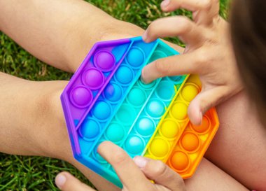 Çocuk stres önleyici pop çalıyor. Seçici odaklanma. İnsanlar