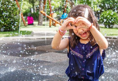 Mutlu çocuk çeşmede oynuyor. Seçici odaklanma. İnsanlar