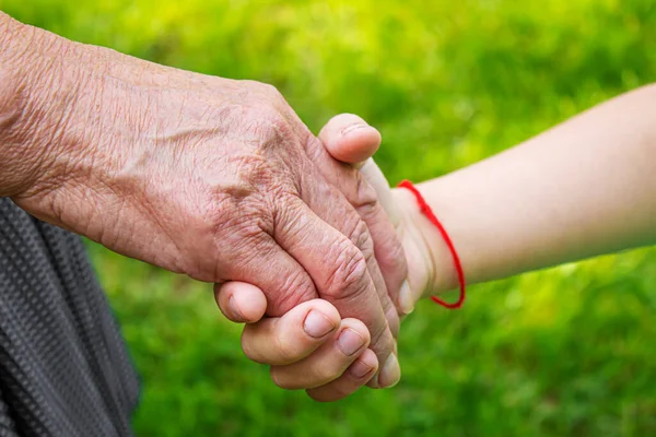 old man holding child\'s hands. selective focus people