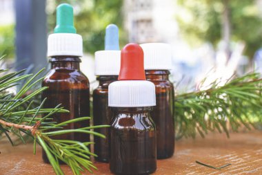 Ahşap zemin üzerinde küçük cam şişelerde sedir ve ladin yağı. Seçici odak, doğa