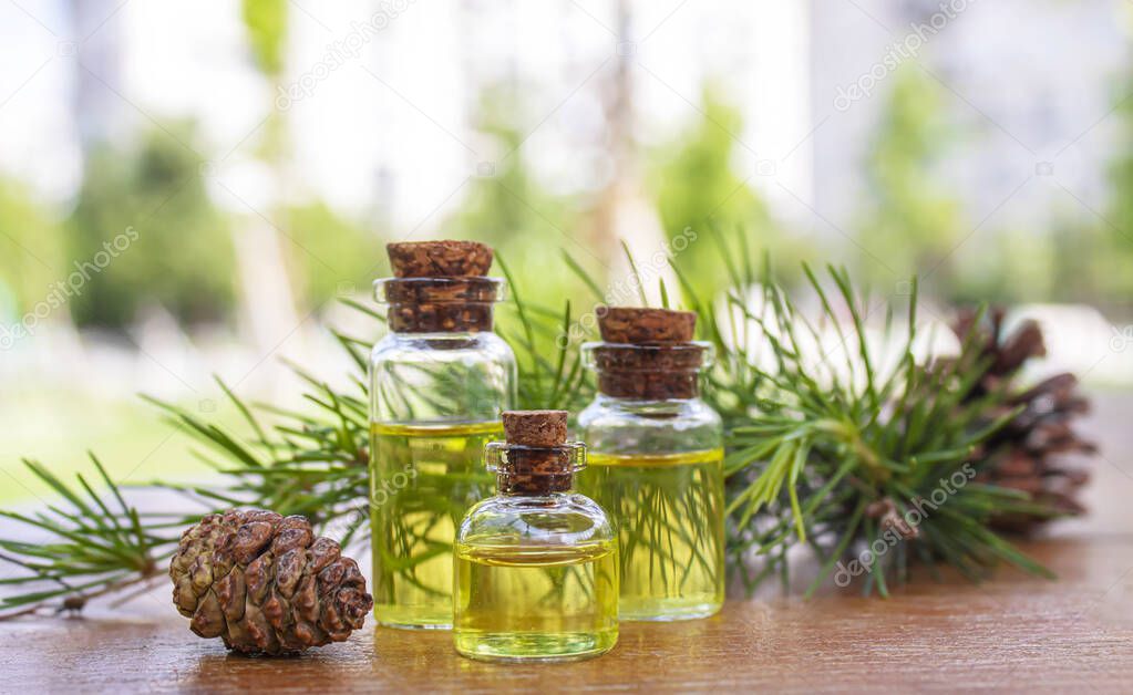 Cedar and spruce essential oil in small glass bottles on wooden background. Selective focus,nature