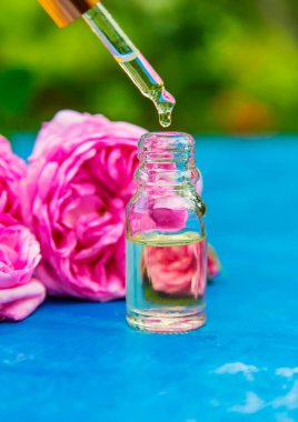 Küçük bir şişede çay gülü yağı. Seçici odaklanma. Doğa