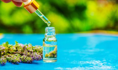 Thyme essential oil in a small bottle. selective focus .nature