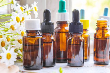 Şişedeki şifalı bitkiler. Papatya yağı özü. Seçici odaklanma. Doğa.