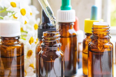 Şişedeki şifalı bitkiler. Papatya yağı özü. Seçici odaklanma. Doğa.