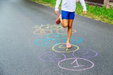 Kaldırımda zıplayan çocuk klasikleri. Seçici odaklanma. Doğa.