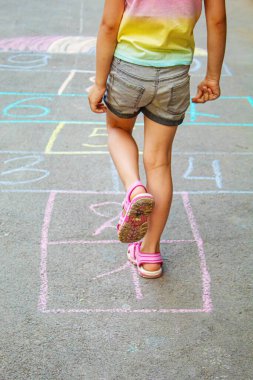 Kaldırımda zıplayan çocuk klasikleri. Seçici odaklanma. Çocuk