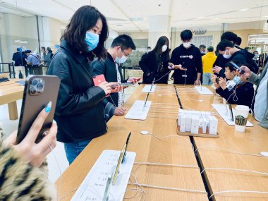 Suzhou, Jiangsu Eyaleti, Çin - 25 Ekim: Yepyeni 5G IPhone 12 'yi tutan şık bir el. Daha çok Apple Store Suzhou Şubesindeki Çinli müşteriler covid-19 'u önlemek için maske takıyor..