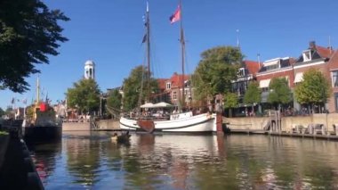 Hollanda 'nın Friesland kentindeki Dokkum şehrinden geçen bir teknede turistler