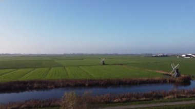 Friesland ve Hollanda 'daki Leeuwarden' ın etrafındaki iki yel değirmenine doğru uçan hava manzarası.