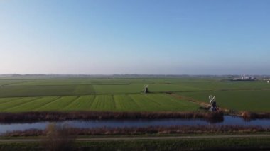 Friesland ve Hollanda 'daki Leeuwarden' ın etrafındaki iki yel değirmenine doğru uçan hava manzarası.