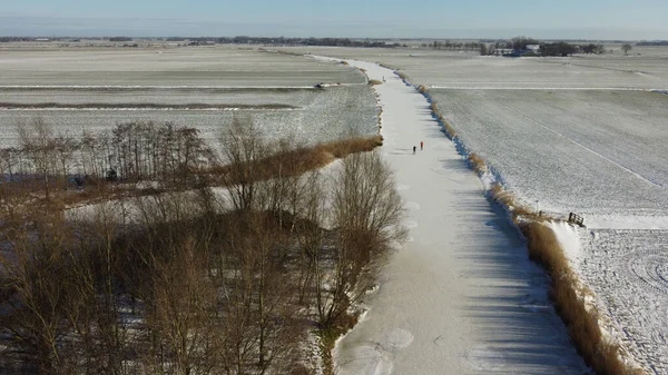 People ice skating on a frozen canal around Sneek in Friesland The Netherlands