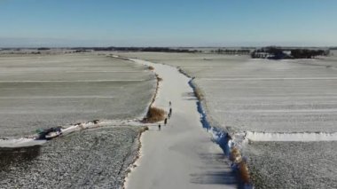 Friesland, Hollanda 'daki Sneek civarında donmuş bir kanalda buz pateni yapan insanlar.