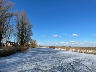 İnsanlar Friesland ve Hollanda 'daki Scharnegoutum civarında donmuş bir kanalda buz pateni yapıyorlar.