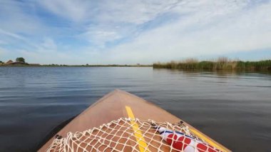 Canoeing on a quiet lake around Heeg in The Netherlands