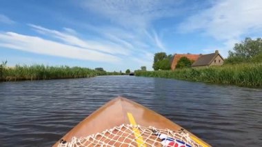 Canoeing on a canal towards Oudega in Friesland, The Netherlands
