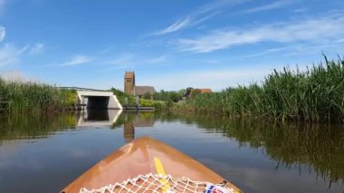 Canoeing on a canal in Westhem Friesland, The Netherlands