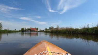 Canoeing on a canal around Abbegea in Friesland, The Netherlands
