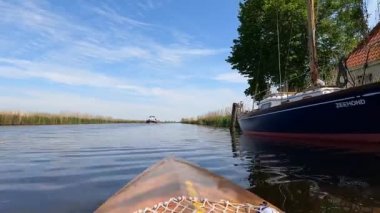 Canoeing on a canal around Abbegea in Friesland, The Netherlands