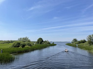 Boat sailing towards a lake around Belt-schultsloot in Weerribben-Wieden National Park the Netherlands
