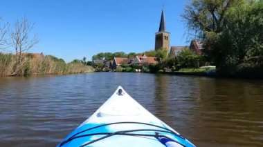 Hollanda, Friesland 'da Burgwerd çevresinde bir kanalda kano gezisi.
