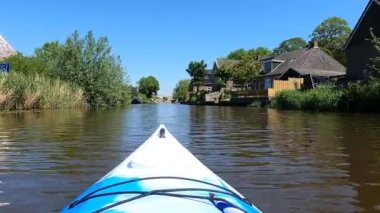 Hollanda, Friesland 'da Burgwerd çevresinde bir kanalda kano gezisi.