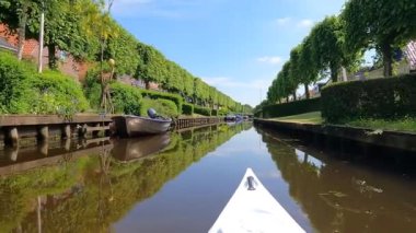 Hollanda, Friesland 'daki IJlst' ten geçen bir kanalda kano gezisi.