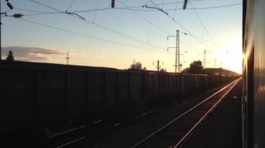 Rusya 'da gün batımında tren istasyonundan ayrılıyor.