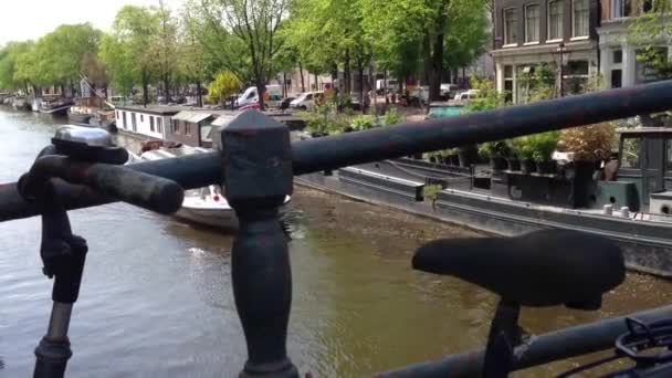 Bicicleta em uma ponte e cruzeiro pelo Canal em Amsterdã, Países Baixos — Vídeo de Stock