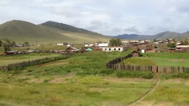 Trans Siberia railway train passing by a village — Stock Video