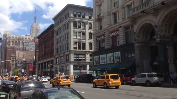 Tráfico en la calle de Manhattan con Empire State, Nueva York, EE.UU. — Vídeo de stock