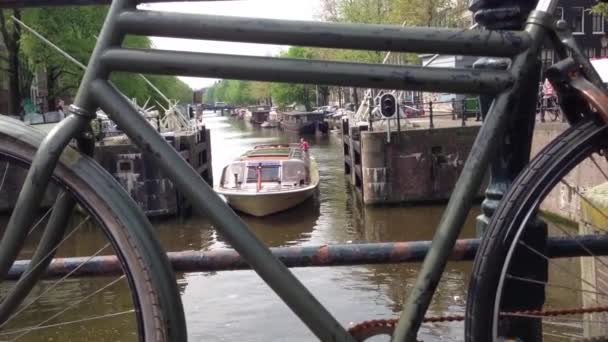 Bicicleta em uma ponte e cruzeiro pelo Canal em Amsterdã, Países Baixos — Vídeo de Stock