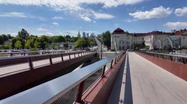 Polonya 'nın Varşova kentindeki Vistula Nehri üzerindeki yaya ve bisiklet köprüsünde yürüyorum.