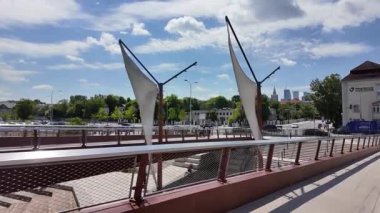 Polonya 'nın Varşova kentindeki Vistula Nehri üzerindeki yaya ve bisiklet köprüsünde yürüyorum.