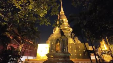Gece Chiang Mai, Tayland 'daki Wat Phra Singh Woramahawihan Budist tapınağına doğru yürüyoruz.