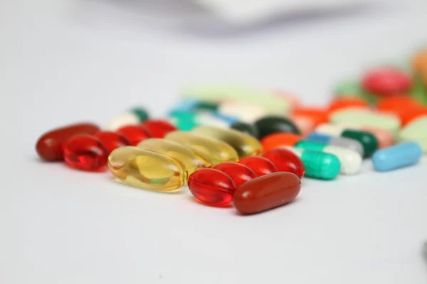 Una pila de tabletas de medicamentos de colores - antecedentes médicos —  Fotos de Stock