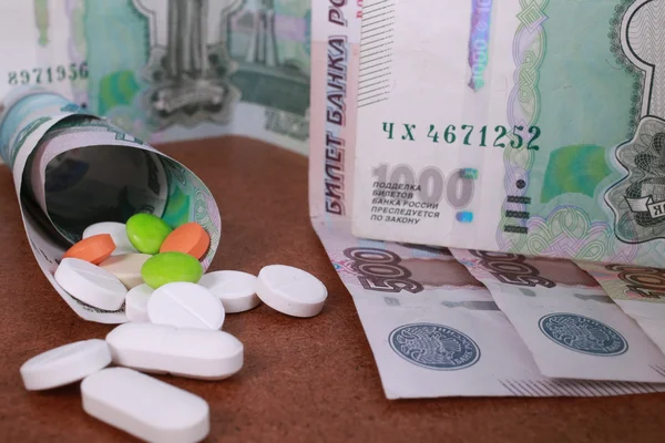 Pillen in verschiedenen Farben auf Geldhintergrund. — Stockfoto
