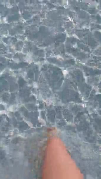 Pies de las mujeres caminando a lo largo del fondo en agua de mar transparente — Vídeos de Stock
