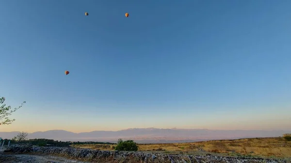 Vadinin üzerindeki mavi gökyüzünde sıcak hava balonları 