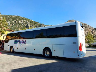 Yolun kenarına büyük bir tur otobüsü park edilmiş.