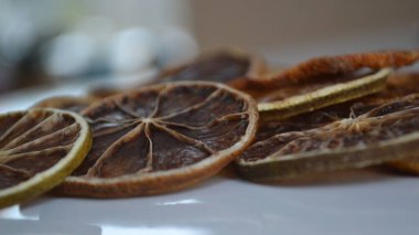 Masanın üzerinde kurumuş kırmızı greyfurt dilimleri var.