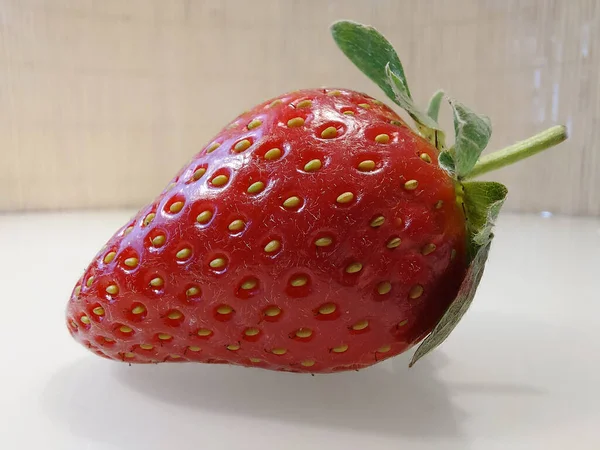 一个大的新鲜草莓特写在白桌上 — 图库照片