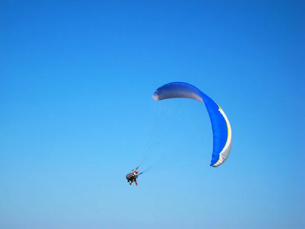 Blue paraglider flying over the ground. — Stock Photo, Image