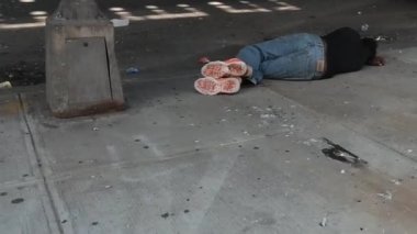 Bronx, New York - 28 Ağustos 2021: Evsiz adam bayıldı ve NYC caddesinde uyuşturucu tedavi hastanesinin yakınında
