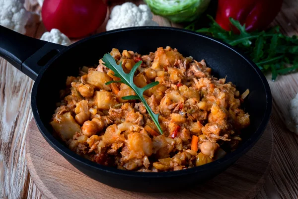 Sebzeli ev yapımı domuz güveci, patates, soğan, havuç, karnabahar, domates soslu biber, sarımsak ve otlar ahşap bir tabakta..