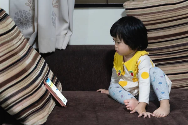 Мила Азіатська Дитина Дивиться Мобільний Телефон Сидить Дивані — стокове фото