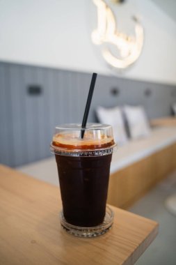 Kafedeki ahşap sehpanın üzerindeki buzlu kahveyi kapat.